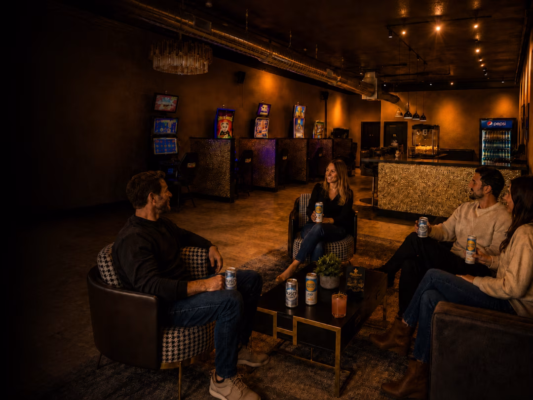 Guests relaxing on the Bacchus Lounge seating with drinks near the gaming floor